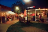 An outdoor dining area with people enjoying meals under string lights.