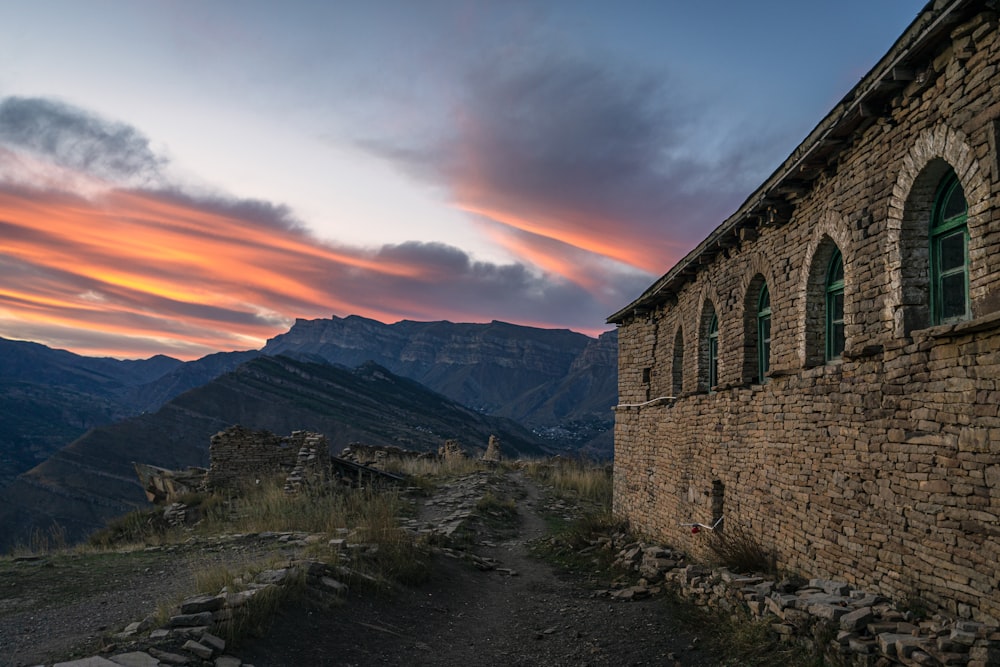 a stone building with a sunset in the background