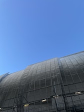 A completed industrial warehouse showcasing a modern metal structure under a clear blue sky.