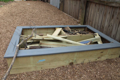 Step-by-step photo of building a raised garden bed in a backyard.