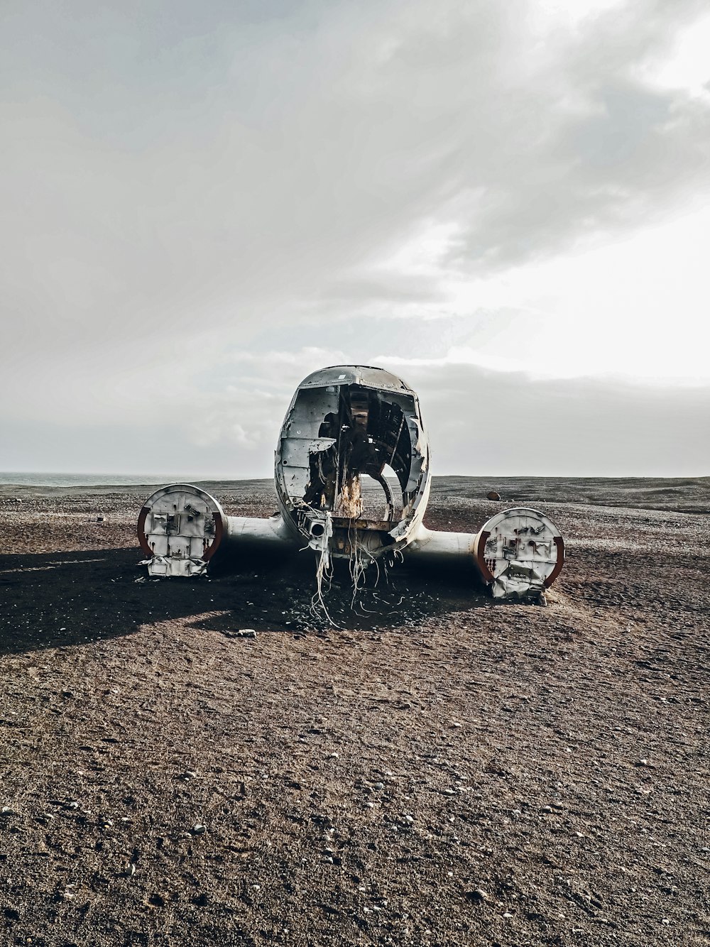 a group of metal structures on a dirt field