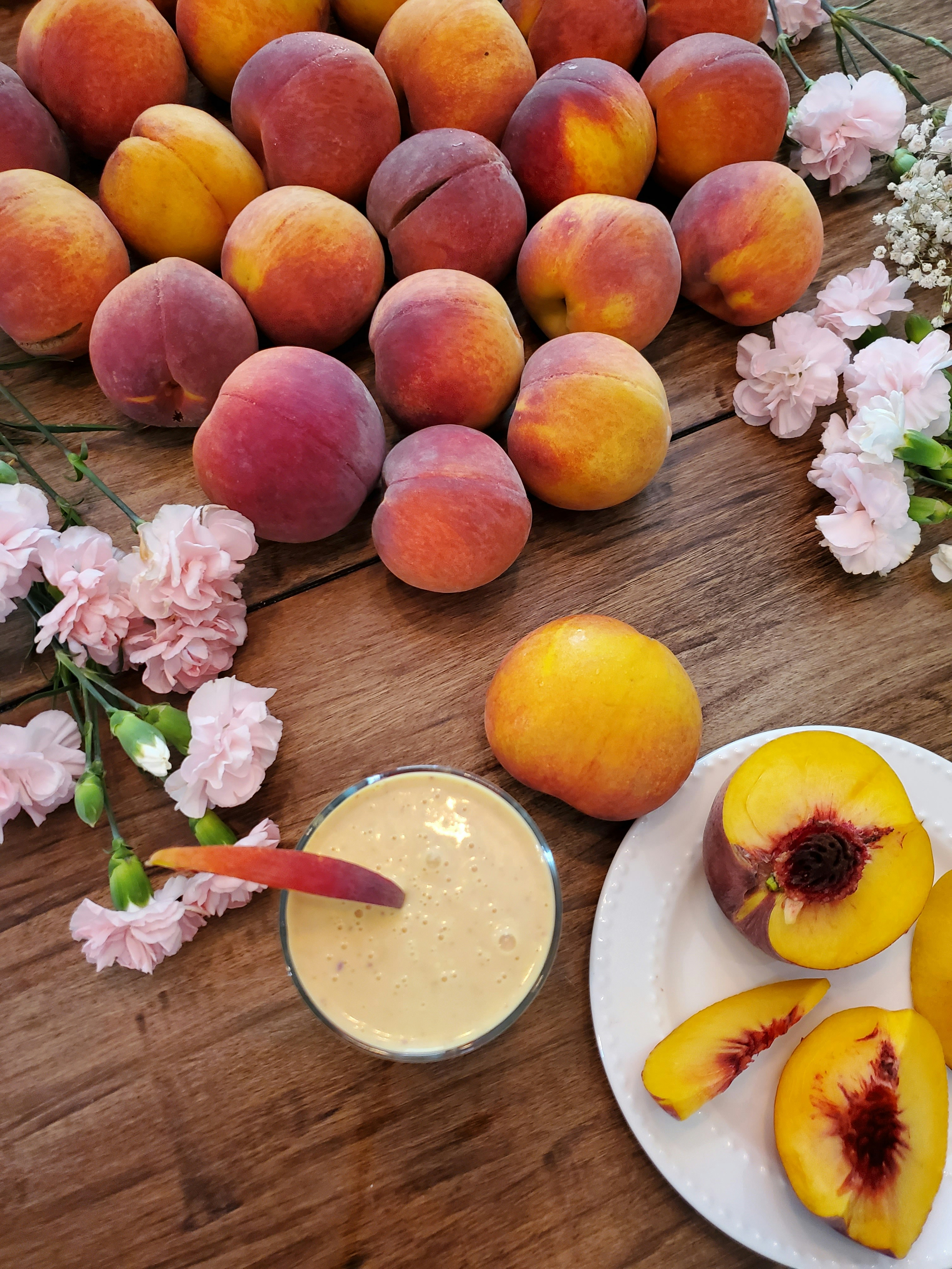 Soft white peaches with pink blush on wooden table