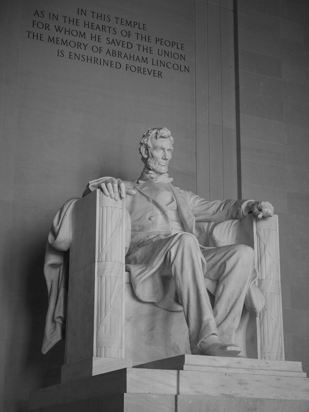 a statue of a man with Lincoln Memorial in the background