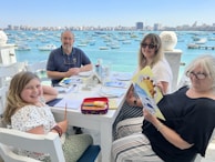 A family enjoying freshly cooked meals at a beachside eatery.