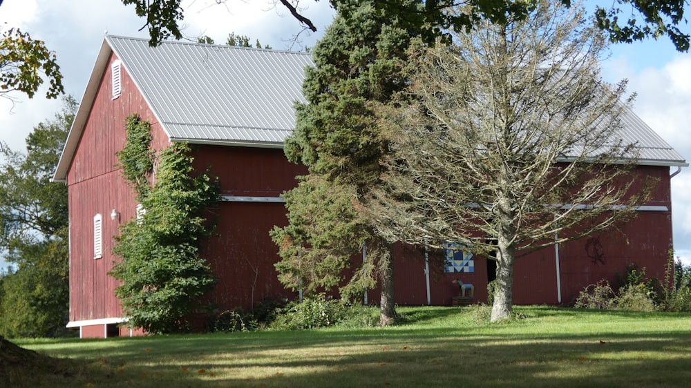 a red barn with trees in front of it