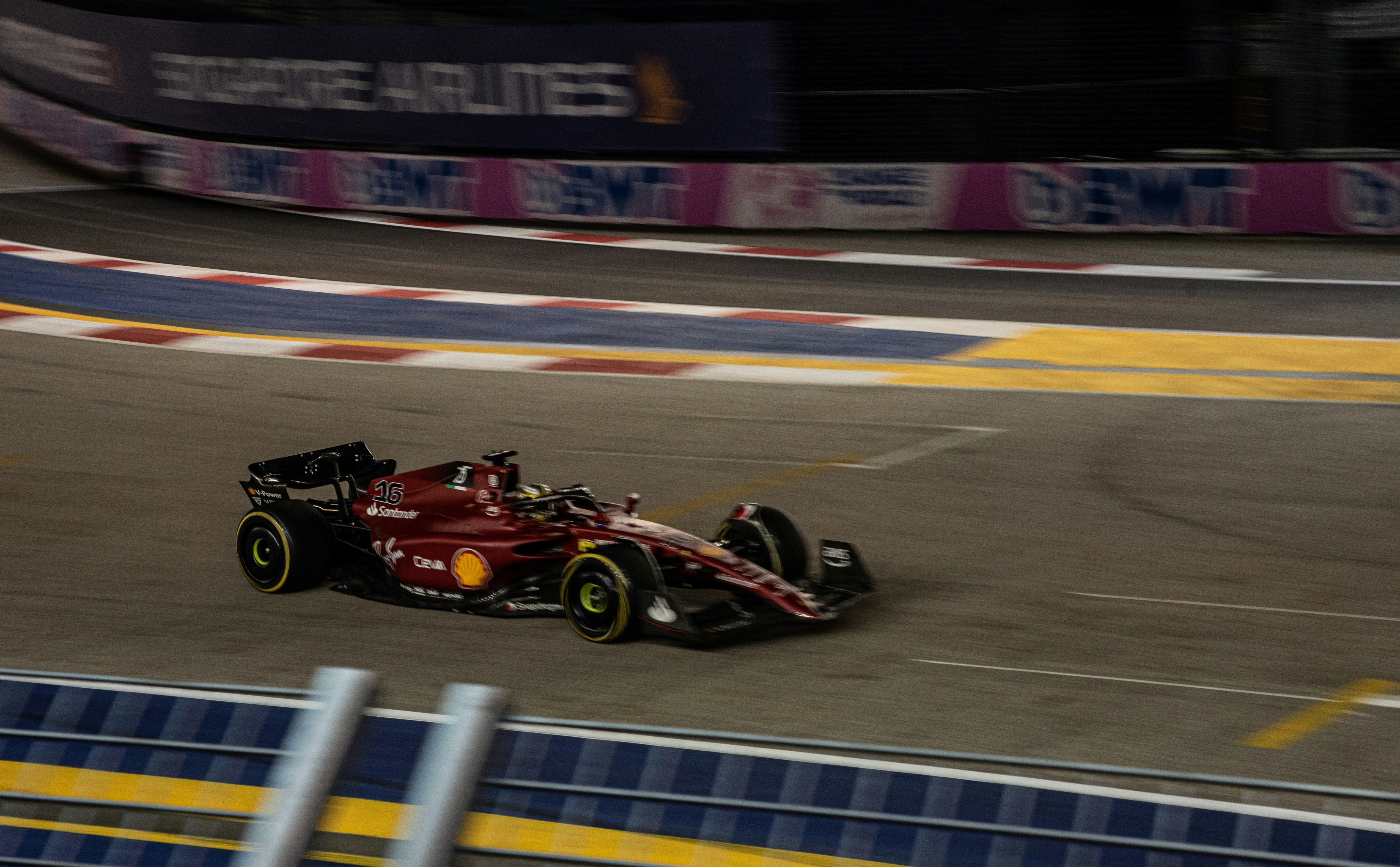Sleek red sports car on neon-lit night track, low angle shot with motion blur on wheels