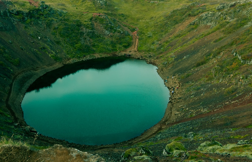 a body of water surrounded by green hills