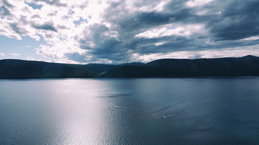 a body of water with mountains in the background