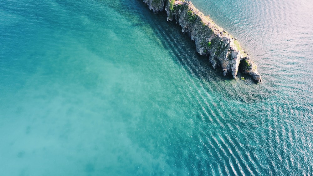 a rocky beach with a body of water in the background