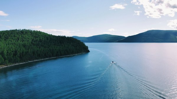 A body of water with trees on the side — Lake Khövsgöl, Mongolia