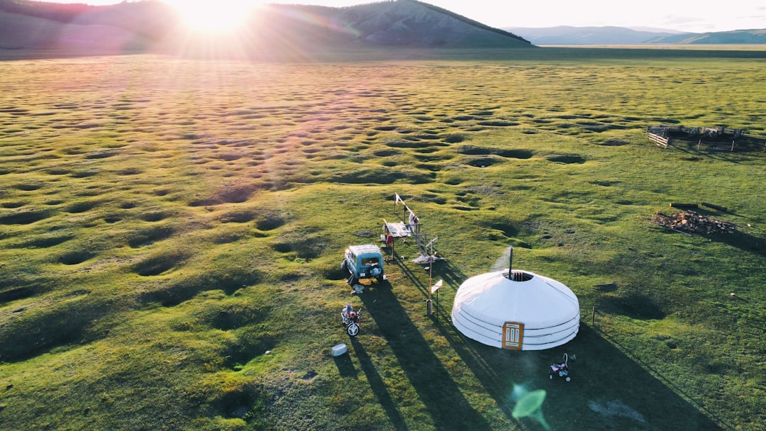 a car parked on a grass field, Sunrise in Mongolia