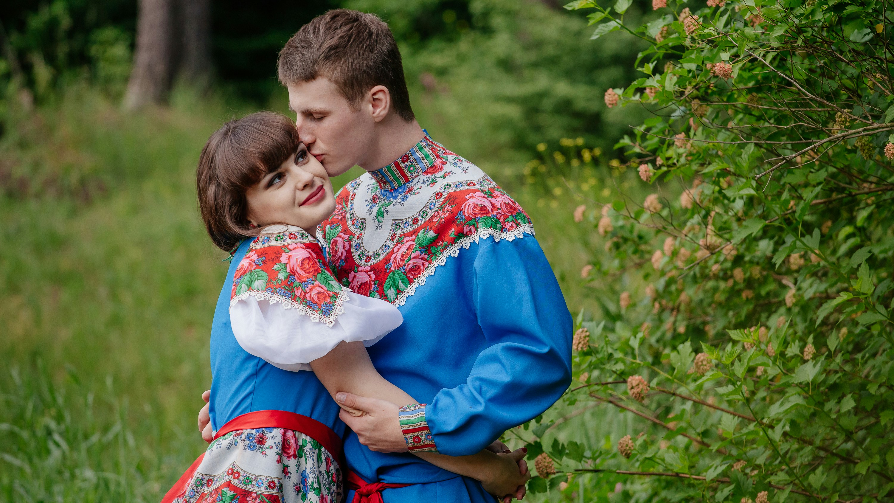 a man and woman sitting in the grass