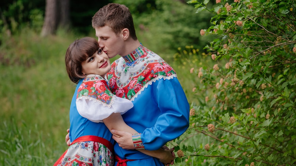 a man and woman sitting in the grass