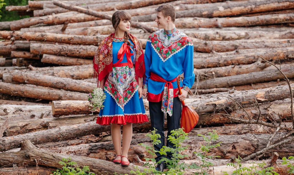 a man and woman standing in front of a log wall