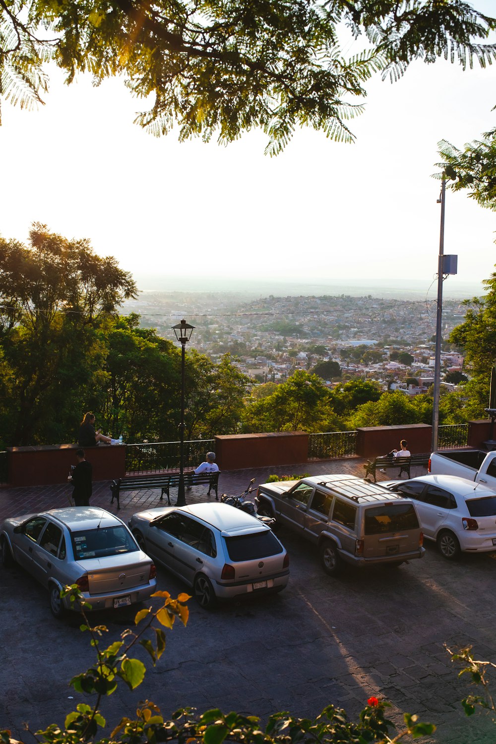 a group of cars parked on a street with a city in the background
