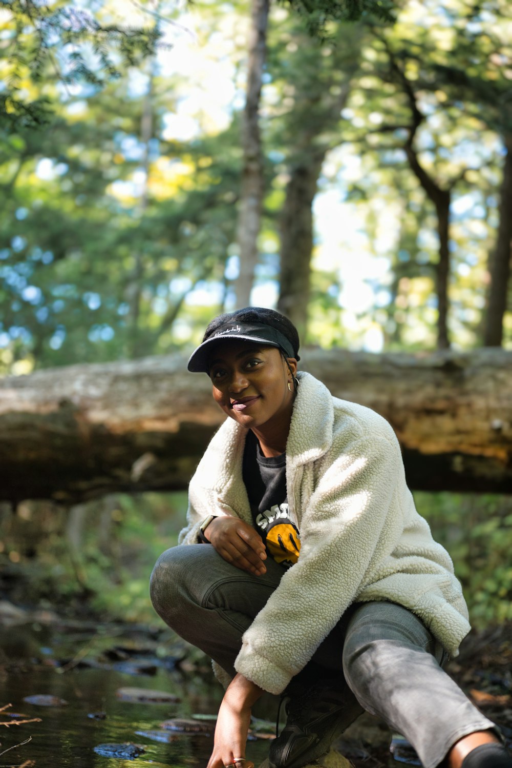 a person sitting on a rock by a river