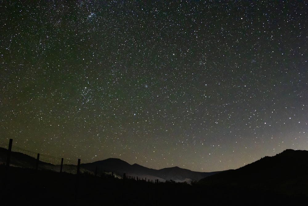 a starry night sky over a mountain range