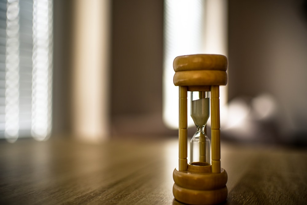 a pair of gold and silver hourglasses on a wooden surface