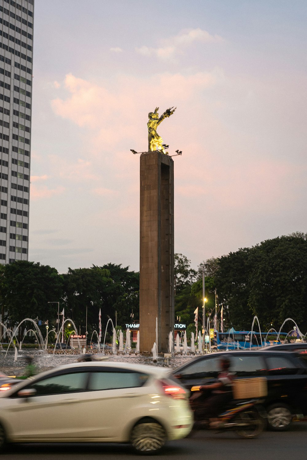 a statue of a person holding a torch in a city