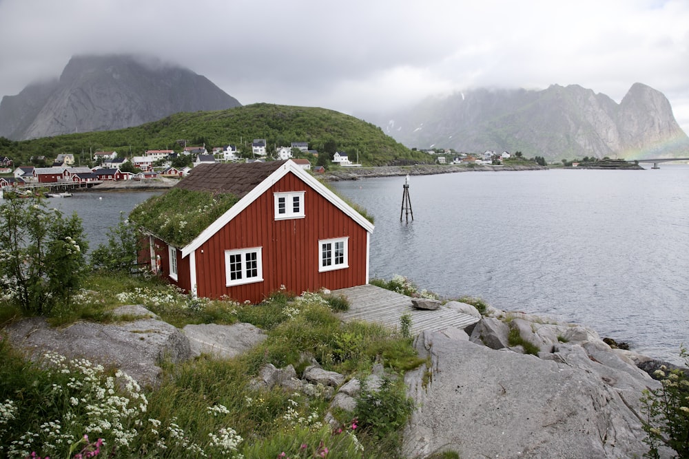 a red house on a rocky shore