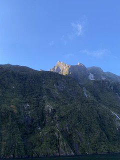 Lush green mountains of Santo Antão with hiking trails under a bright blue sky.