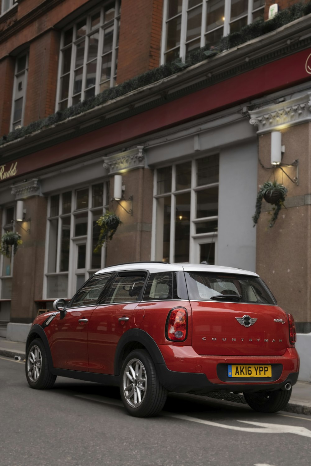 a red car parked in front of a building