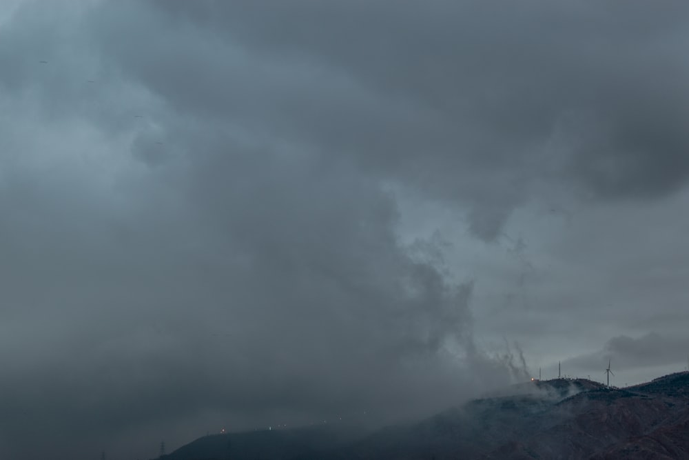 a cloudy sky over a snowy mountain