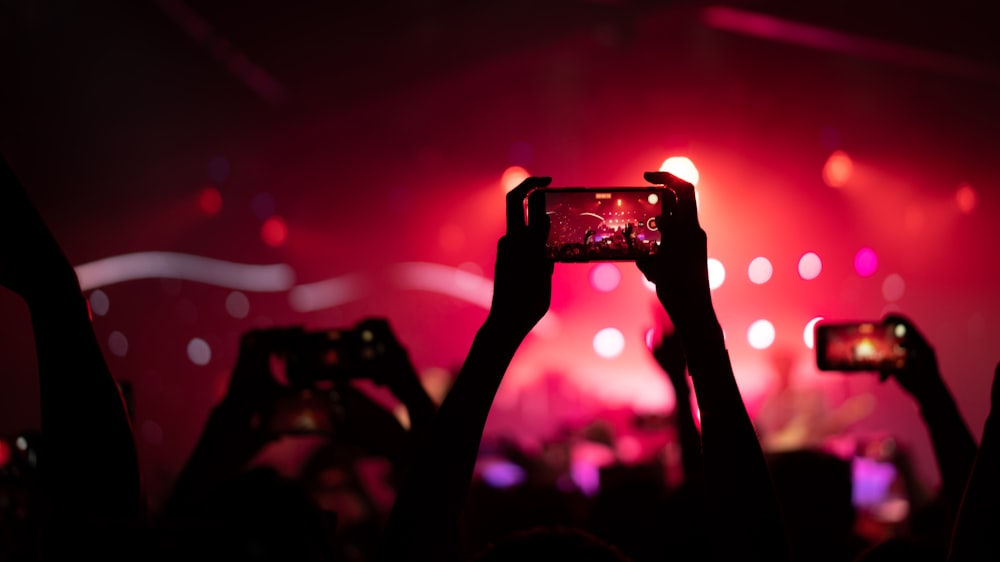 a person holding a camera in front of a crowd