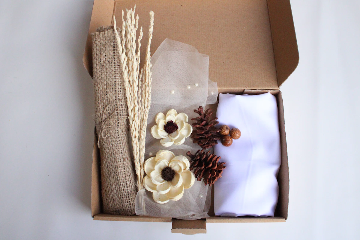 Une box en carton kraft garnie de fleurs séchées et de linge blanc