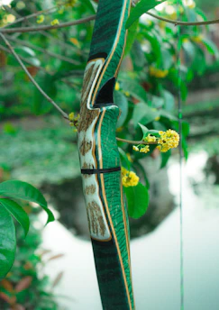 A delicate sugarcane bow adorned with blooming flowers, symbolizing Manmatha's divine weapon.