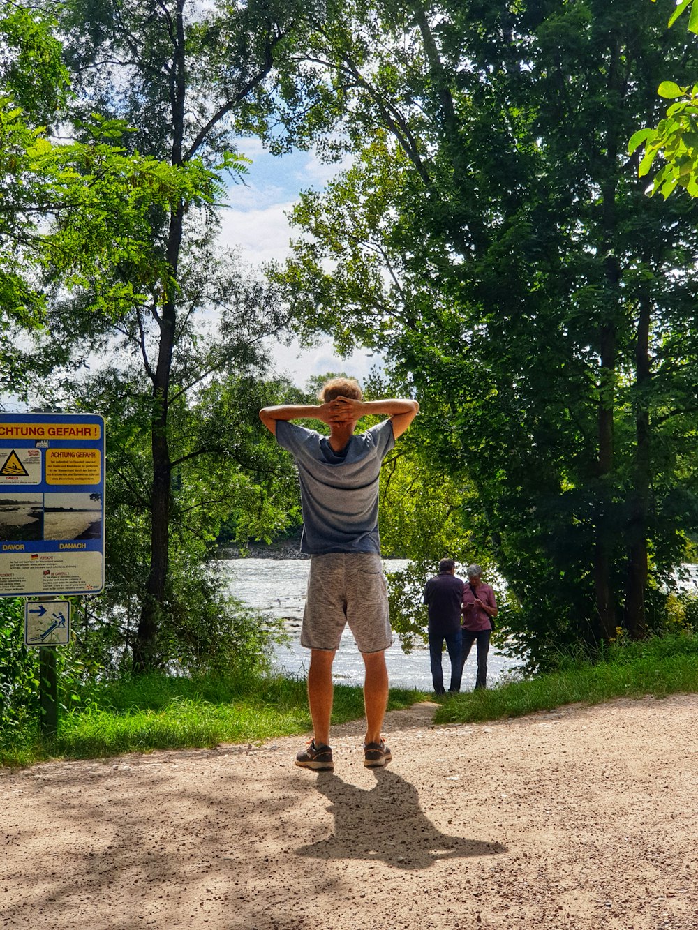 a man standing on a dirt path with his arms up