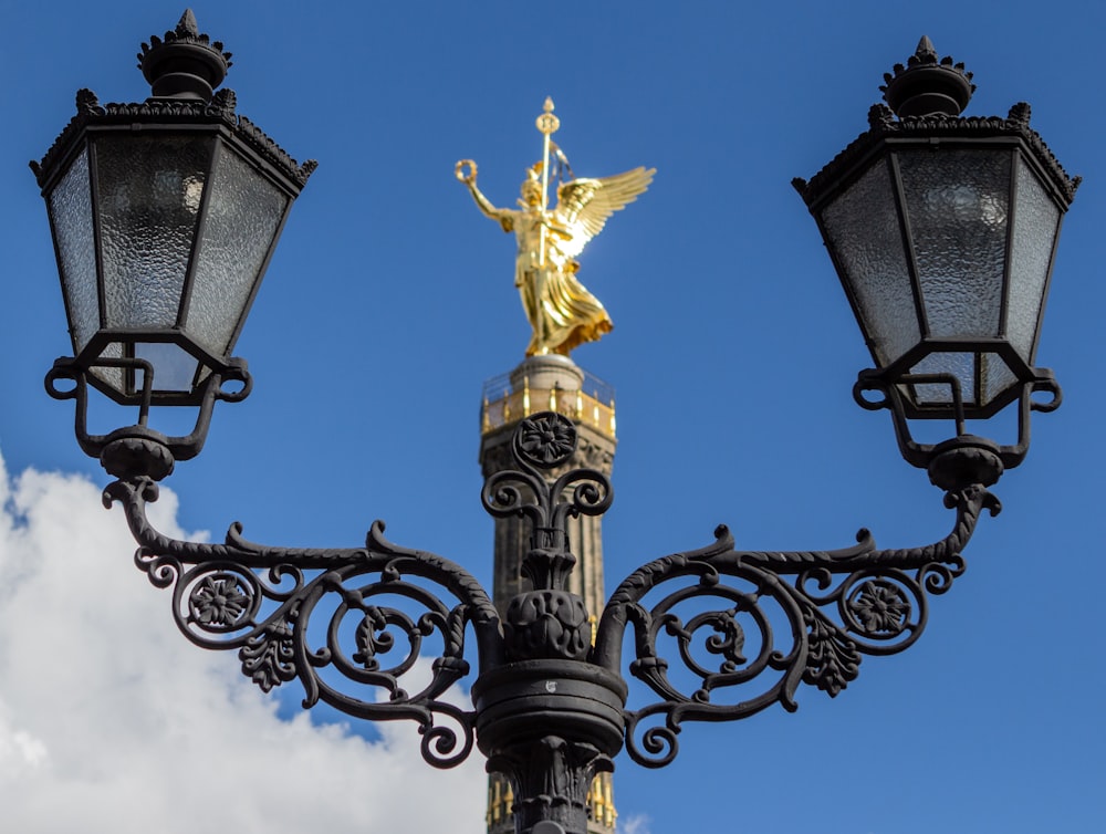 a group of street lamps with a golden statue on top