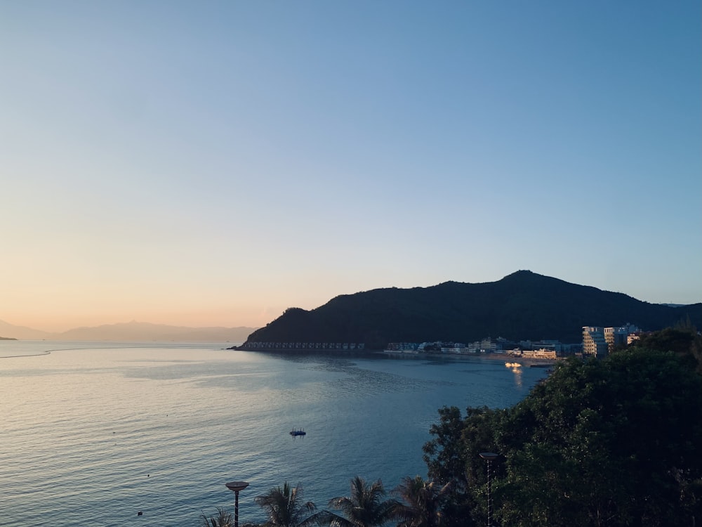 a body of water with a hill in the background