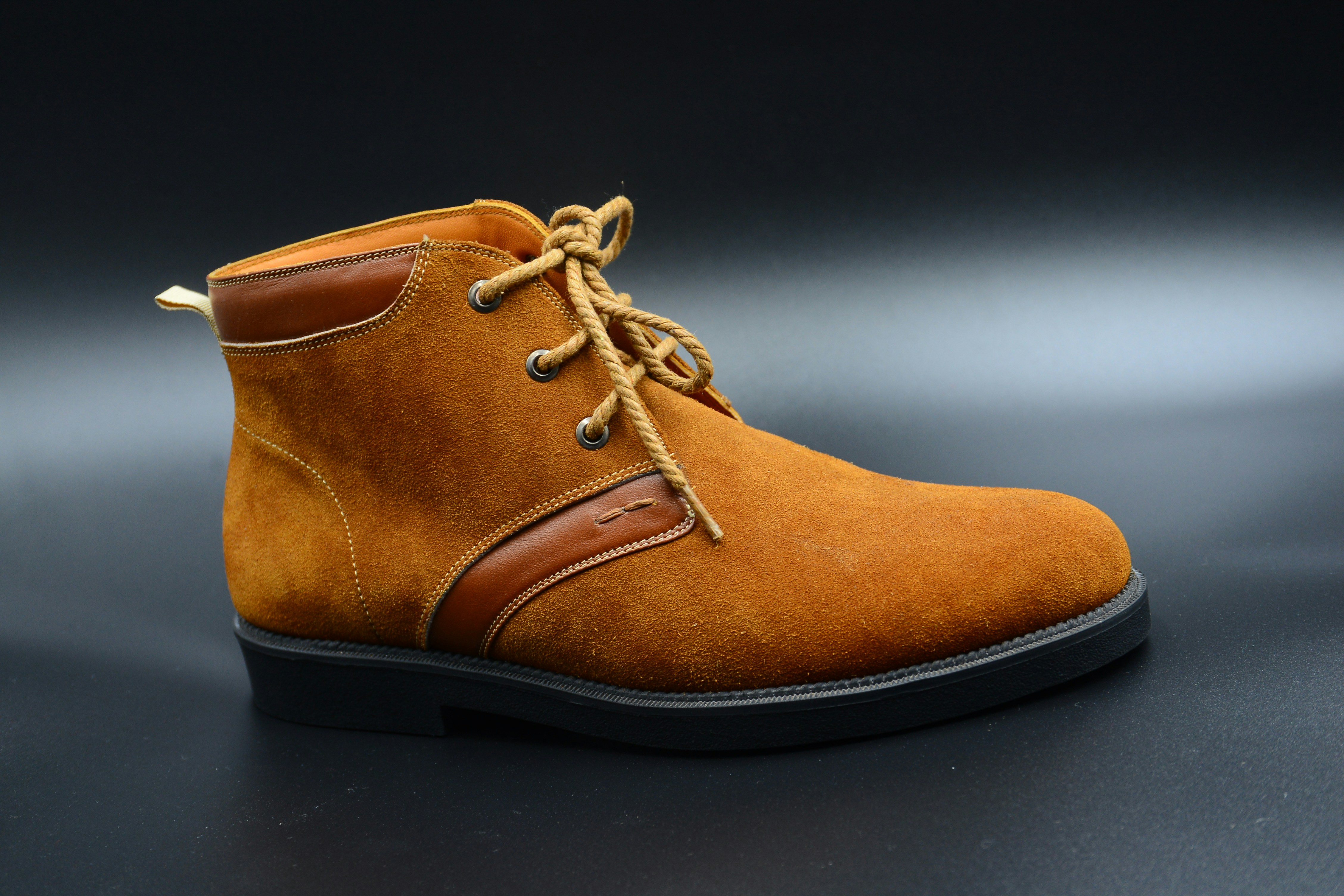 Tan suede chelsea boot on clean white surface, minimal product photography