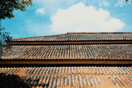 A wide-angle 4K photo capturing multiple metal sheet sheds with blue roofs arranged in an open field in India.
