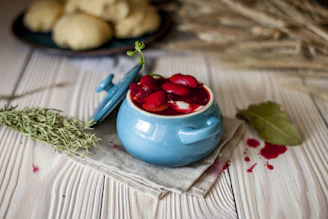 A colorful ceramic pot filled with a traditional Romanian soup on a cozy kitchen counter.