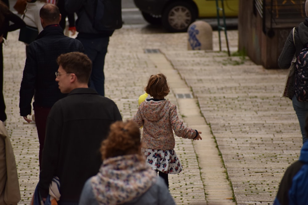 a group of people standing on a sidewalk