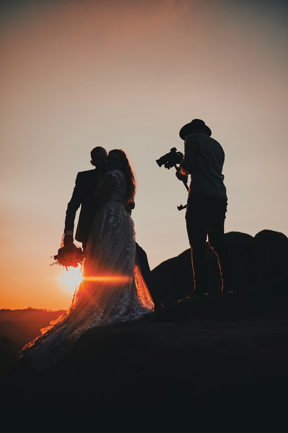 a group of people standing on a mountain with a fire in the background