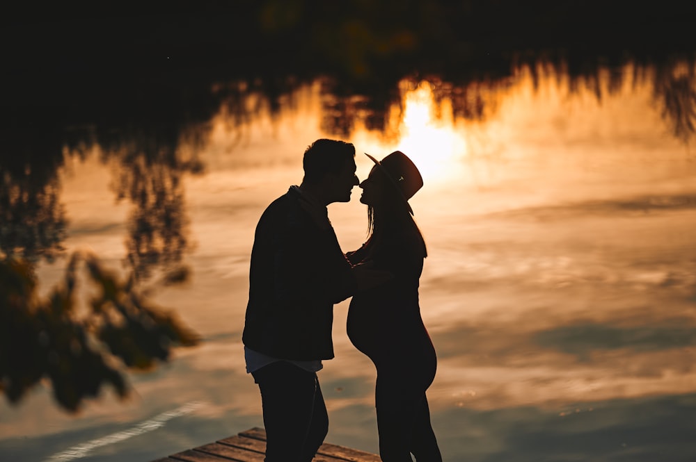 a man and woman kissing in front of a fire