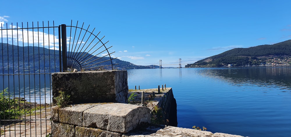 a stone fence overlooking a body of water