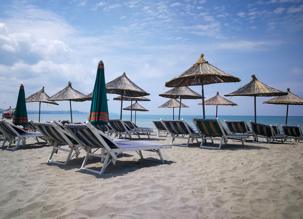 a beach with umbrellas and chairs