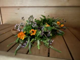 Artisan arranging a natural bouquet with local flowers in a rustic workshop.