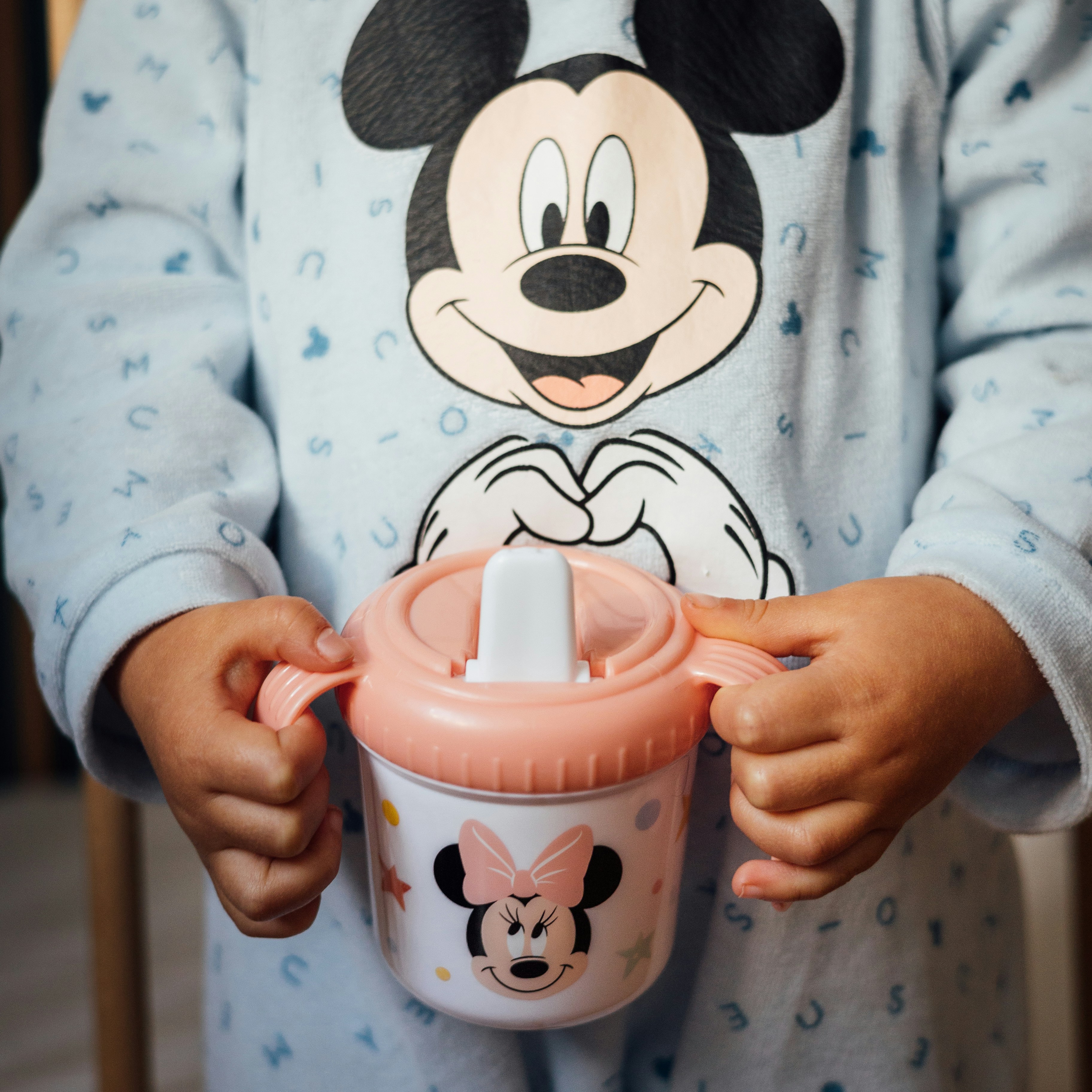 a person wearing a garment holding a cup with a lid