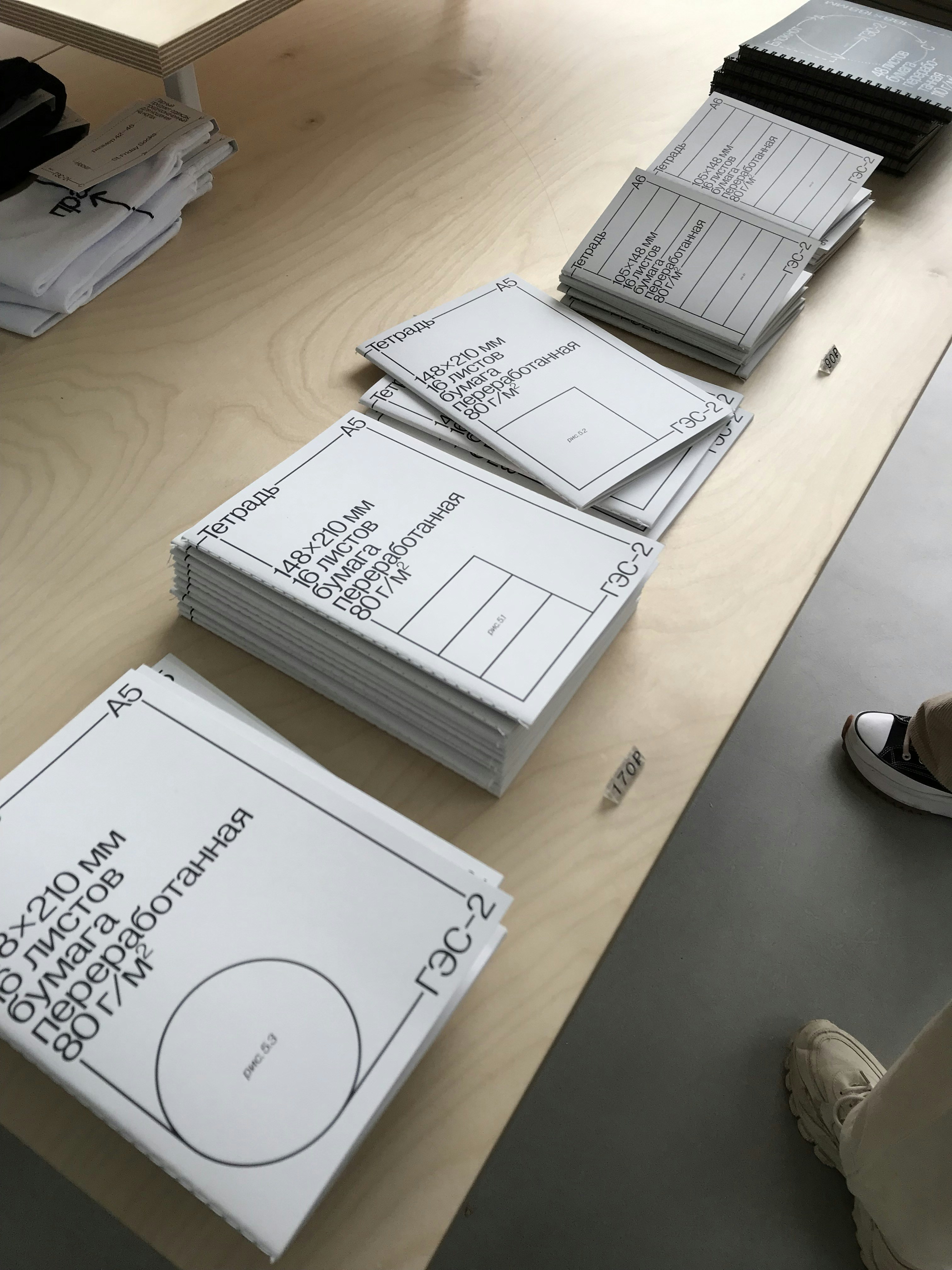 Neatly stacked black and white printed school assignment pages with clear text on a wooden desk