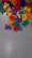 Colorful plastic alphabet letters scattered across a light gray surface. The letters are vibrant, including red, blue, yellow, green, orange, and purple shades. They appear to be jumbled and are likely used for educational or playful purposes.