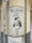 A vintage-style sign is mounted on a corner wall, depicting a woman in traditional attire holding a container. The text on the sign reads 'Mallorcaria' at the top and 'Vins' at the bottom. The sign appears weathered, adding an old-world charm.