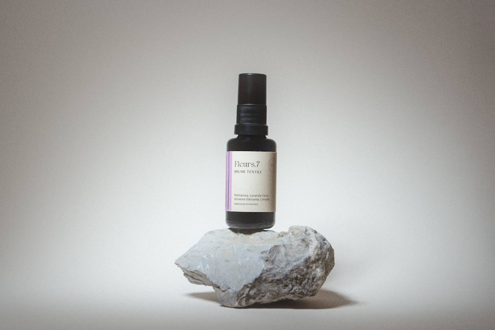 a bottle of perfume on a rock
