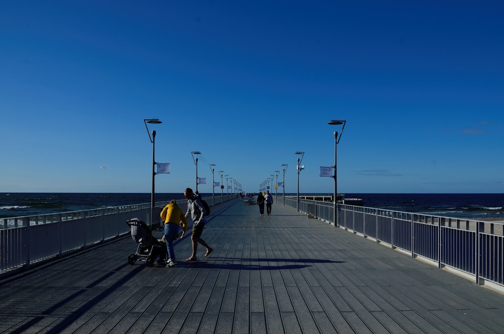 a group of people walking on a boardwalk