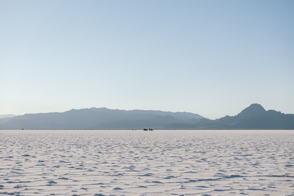 a body of water with mountains in the background