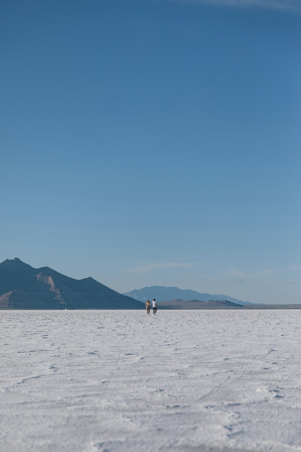 Un par de personas caminando sobre un campo nevado